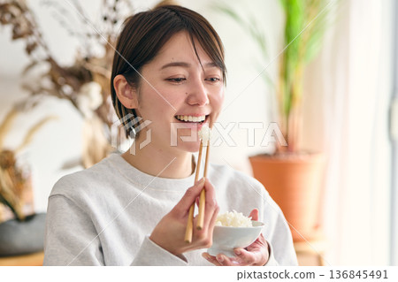 A woman eating rice 136845491