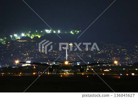 Night view of Itami Airport with a plane landing Night view of Itami Airport with a plane landing 136845627