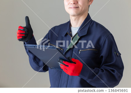 一位身著工作服的中年男性商務人士,手持文件夾,豎起大拇指 一位身著工作服的中年男性商務人士,手持文件夾,豎起大拇指 136845691