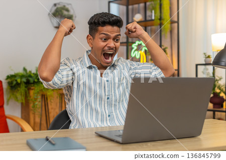Indian man says wow as laptop alert shows prize news celebrates win feels proud of finished project 136845799