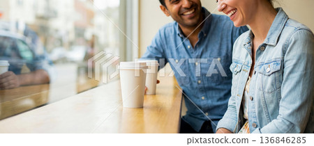 conversation over a cup of coffee, a date in a cafe, a couple talking while sitting at a counter by the window in a cafe shop, copy space for advertising 136846285
