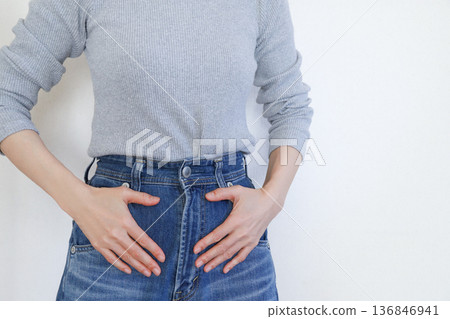 一張女性手撫下腹部的圖片，可能表示經痛或腹痛。 136846941