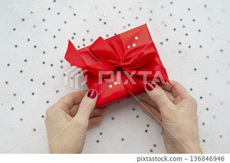 Female hands holding red Christmas gift box Female hands holding red Christmas gift box 136846946