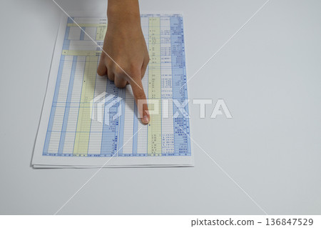 A person's hand checking the results of a health check 136847529