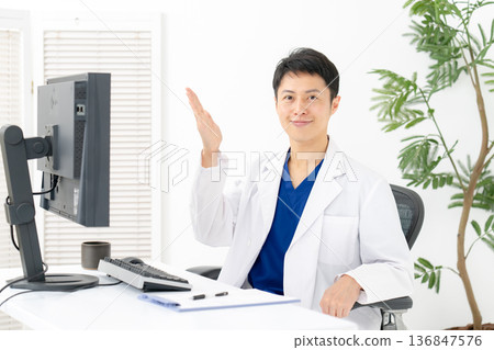Medical man in white coat waving his hand 136847576