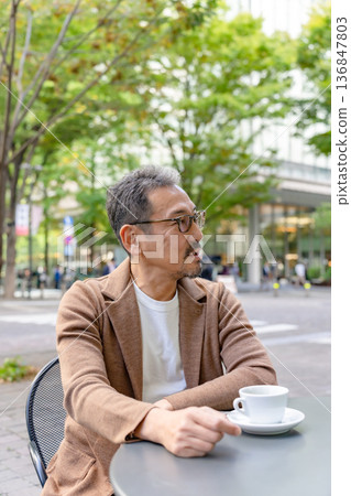 Man drinking coffee on the terrace 136847803
