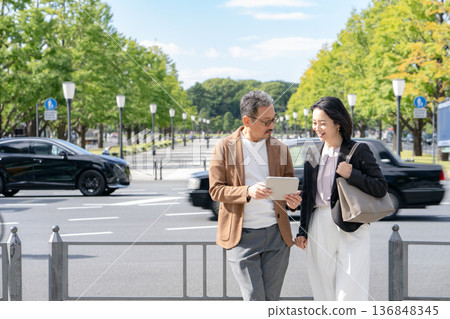 Two people talking while looking at a tablet Business Two people talking while looking at a tablet Business 136848345