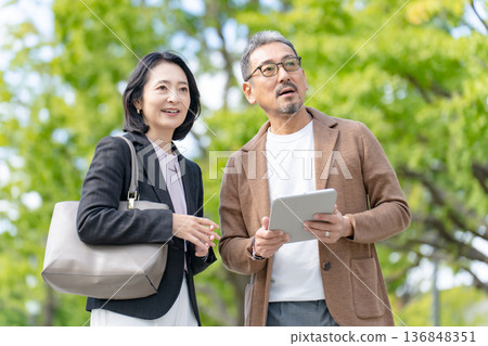 兩個人一邊看著平板電腦一邊交談 商業 136848351