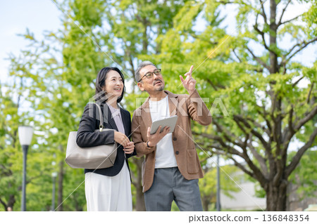 Two people talking while looking at a tablet Business Two people talking while looking at a tablet Business 136848354