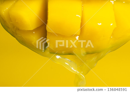 Mango juice dripping from fresh fruit, yellow background Mango juice dripping from fresh fruit, yellow background 136848591