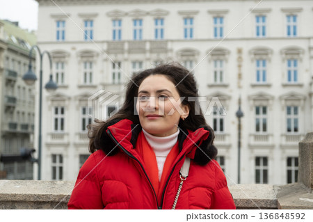 Portrait of a young woman in red winter jacket on city street Portrait of a young woman in red winter jacket on city street 136848592