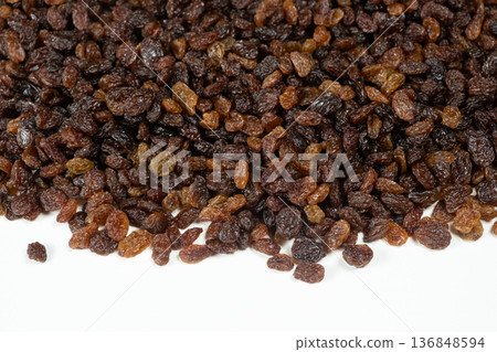 Pile of brown raisins isolated on white background. 136848594