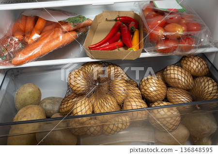 Organizing fresh organic vegetables in the fridge. 136848595