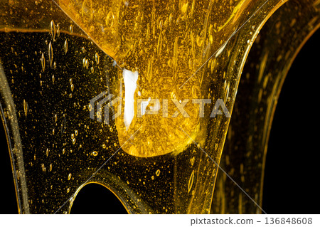 Macro Texture Of Liquid Fresh Honey On Black Background. Macro Texture Of Liquid Fresh Honey On Black Background. 136848608