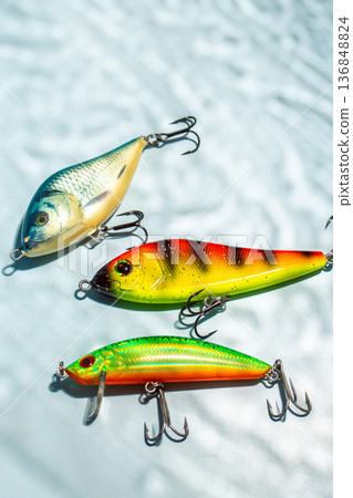 Flat lay of fishing equipment on blue background with water shadows. Close up of tackles and baits Flat lay of fishing equipment on blue background with water shadows. Close up of tackles and baits 136848824