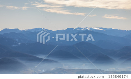 Misty mountain range with snow-capped peaks. The Velka Fatra national park in northwest of Slovakia, Europe. Misty mountain range with snow-capped peaks. The Velka Fatra national park in northwest of Slovakia, Europe. 136849174