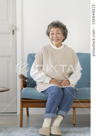 坐在沙發上微笑的高級女人 坐在沙發上微笑的高級女人 136849813