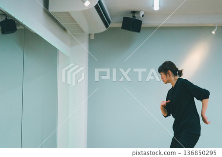 一位女士在全鏡面舞蹈工作室練習舞蹈。 一位女士在全鏡面舞蹈工作室練習舞蹈。 136850295