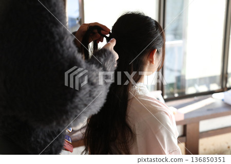 A woman who makes a hair makeup 136850351