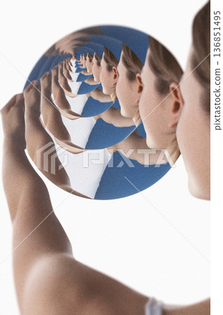 Woman seeing infinite reflection in circular mirror effect 136851495