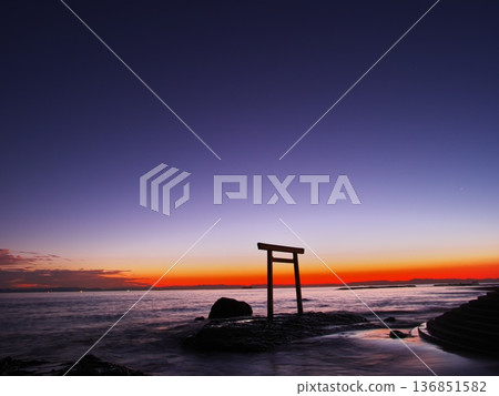 Chita Peninsula in autumn: The Tsubutegaura Torii gate stands against the backdrop of a sunset-colored sky Chita Peninsula in autumn: The Tsubutegaura Torii gate stands against the backdrop of a sunset-colored sky 136851582