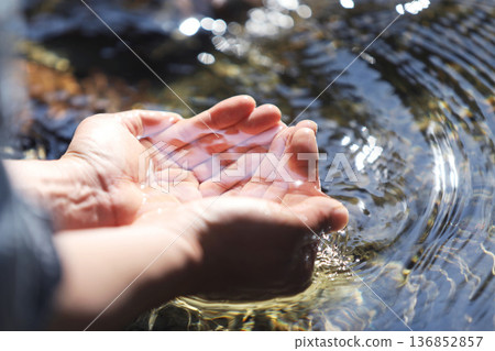 The clear, clean water of a pristine stream, the precious water of life held in your hands, World Water Day background The clear, clean water of a pristine stream, the precious water of life held in your hands, World Water Day background 136852857