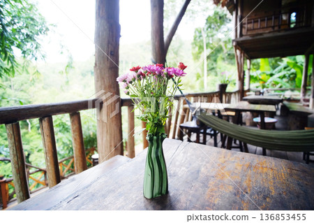 Close up blooming fresh pink flowers branch in green ceramic vase decorated on wooden table in vintage house of Thailand 136853455