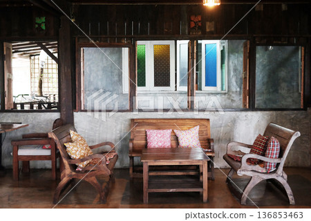 Brown wooden chairs and with sofa and table set on a wooden in vintage living room in Thailand 136853463