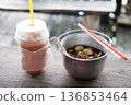 Thai boat noodles with chicken soup and pork balls in aluminum bowl with iced coffee in plastic glass on wooden table 136853464