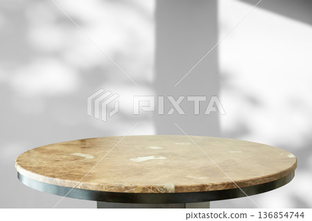 Round marble table top with tree leaves shadow drop on white wall background for mockup product display 136854744