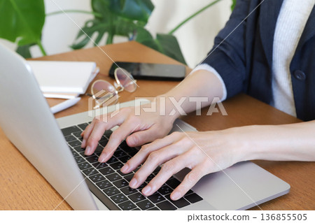Hands of a woman working on a laptop 136855505