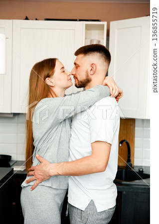 Young couple hugging in kitchen, romantic relationship concept 136855719