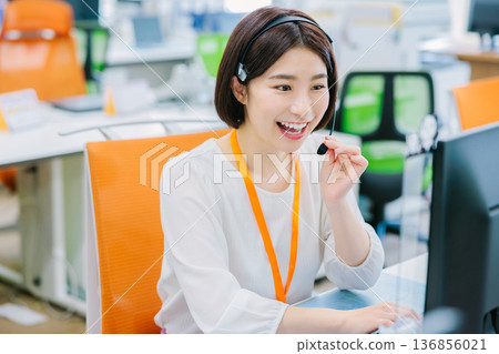 Female operator receiving a call in the office Female operator receiving a call in the office 136856021