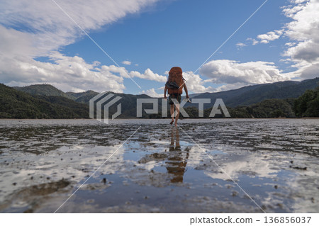 Barefoot hiker crossing tidal Awaroa Inlet on Abel Tasman Track, NZ Barefoot hiker crossing tidal Awaroa Inlet on Abel Tasman Track, NZ 136856037