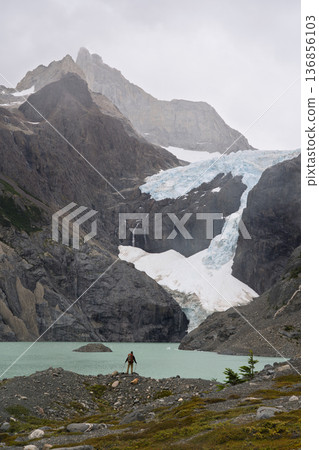 Hiker standing by Laguna Los Perros below massive glacier, Patagonia, Chile Hiker standing by Laguna Los Perros below massive glacier, Patagonia, Chile 136856103