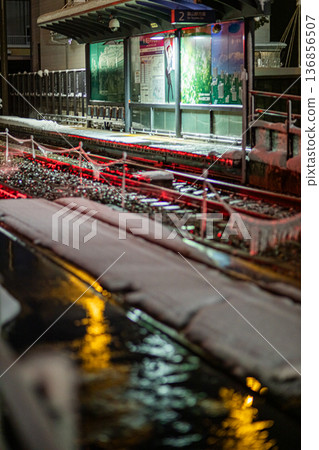 Toyama streetcars operating on a cold, snowy night 136856507