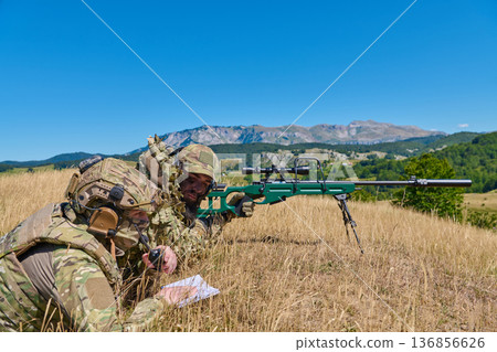 Military Sniper Team Training With Precision Rifle in Camouflage on Mountain Field During Daytime Exercise Military Sniper Team Training With Precision Rifle in Camouflage on Mountain Field During Daytime Exercise 136856626