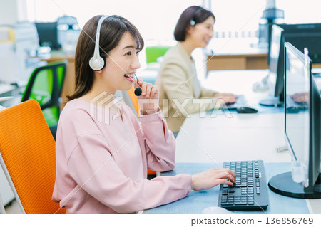 Female operator receiving a call in the office Female operator receiving a call in the office 136856769