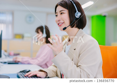 Female operator receiving a call in the office Female operator receiving a call in the office 136856770