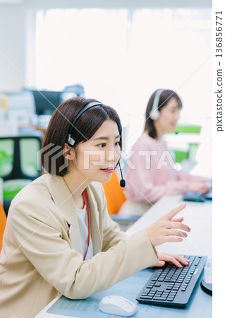 Female operator receiving a call in the office Female operator receiving a call in the office 136856771