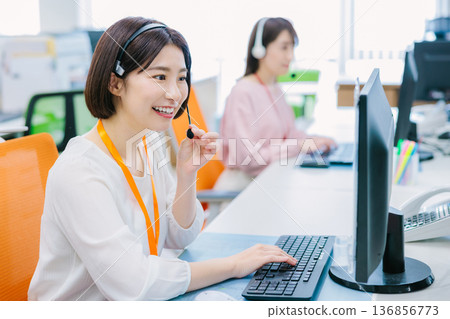 Female operator receiving a call in the office Female operator receiving a call in the office 136856773