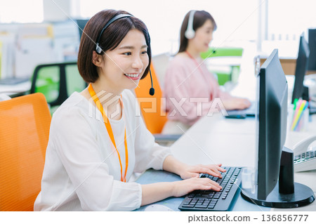 Female operator receiving a call in the office 136856777