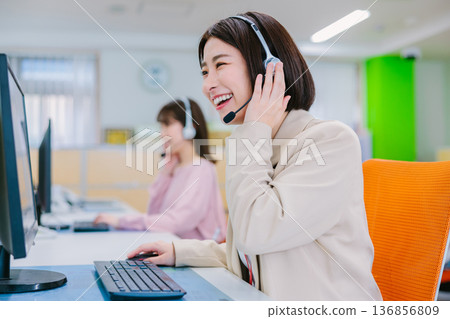 Female operator receiving a call in the office Female operator receiving a call in the office 136856809