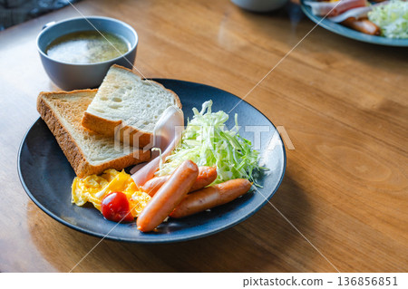 A Western-style breakfast plate featuring toast, sausage, egg dishes, and shredded cabbage A Western-style breakfast plate featuring toast, sausage, egg dishes, and shredded cabbage 136856851