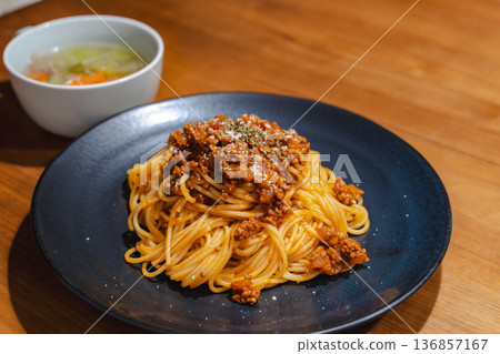 Dinner of pasta and soup served on black plates photographed on a wooden table Dinner of pasta and soup served on black plates photographed on a wooden table 136857167