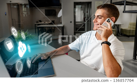Man using smartphone and laptop while talking at modern office space during the day Man using smartphone and laptop while talking at modern office space during the day 136857704