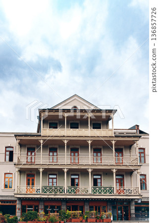 Historic building with balconies under a cloudy sky in a city setting Historic building with balconies under a cloudy sky in a city setting 136857726