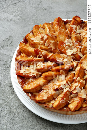 Baked apple pie with almond slices on a white plate ready to serve Baked apple pie with almond slices on a white plate ready to serve 136857745