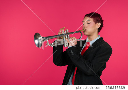 Musician playing trumpet against pink background Musician playing trumpet against pink background 136857889