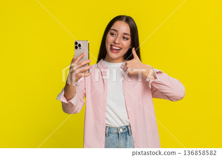 Woman playfully sticking out tongue making funny faces at smartphone recording social media video Woman playfully sticking out tongue making funny faces at smartphone recording social media video 136858582